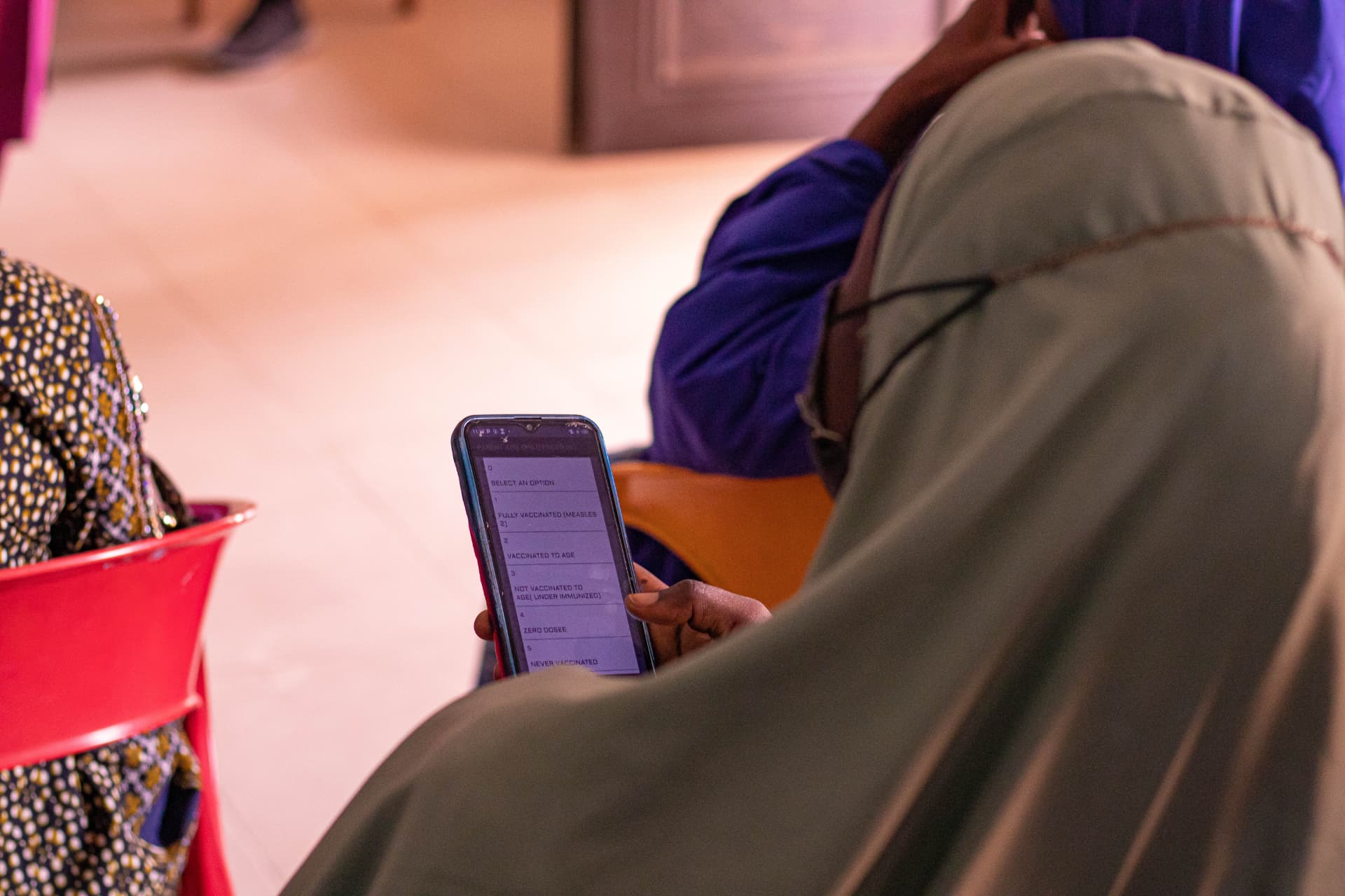 A healthcare worker reviewing a child's immunisation record in C-Tracka